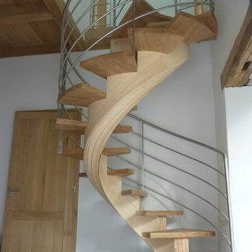 Escalier circulaire à limon central lamellé-collé débillardé