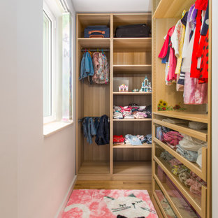 Kleiner Moderner Begehbarer Kleiderschrank mit flächenbündigen Schrankfronten, hellbraunen Holzschränken und Teppichboden in Sonstige