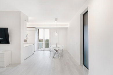 Immagine di una sala da pranzo aperta verso il soggiorno contemporanea di medie dimensioni con pareti bianche, pavimento in vinile e pavimento bianco