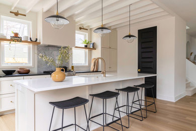 Eat-in kitchen - contemporary galley eat-in kitchen idea in Grand Rapids with an undermount sink, beige cabinets, quartzite countertops, gray backsplash, quartz backsplash, stainless steel appliances, an island and white countertops