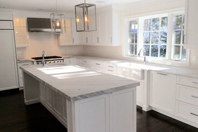 Inspiration for a large transitional l-shaped eat-in kitchen in New York with a farmhouse sink, shaker cabinets, white cabinets, marble benchtops, white splashback, subway tile splashback, stainless steel appliances, dark hardwood floors and with island.