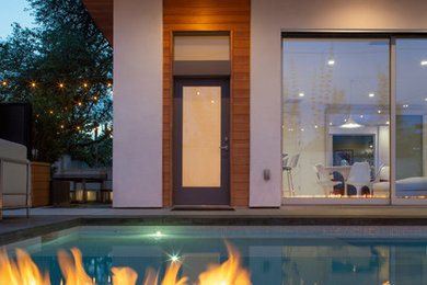 This is an example of a mid-sized modern courtyard rectangular pool in Austin with a hot tub and decking.