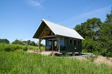 Small rustic gray one-story wood and board and batten tiny house idea in Minneapolis with a shed roof, a metal roof and a white roof