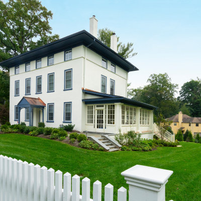 Large elegant beige four-story stucco house exterior photo in Philadelphia with a mixed material roof and a gray roof