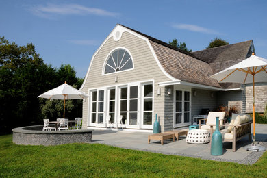 Example of a mid-sized classic beige one-story wood exterior home design in New York with a gambrel roof