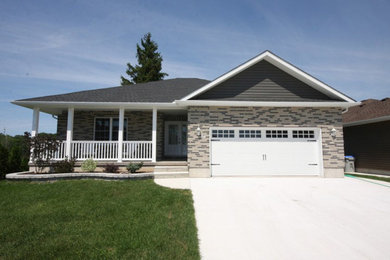 Example of a small classic gray one-story stone house exterior design in Other with a hip roof and a shingle roof