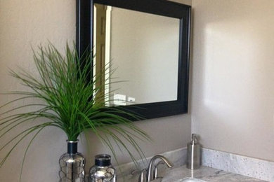 Example of a mid-sized transitional master beige tile and stone tile light wood floor and beige floor bathroom design in Phoenix with shaker cabinets, dark wood cabinets, a two-piece toilet, beige walls, an undermount sink, marble countertops and a hinged shower door