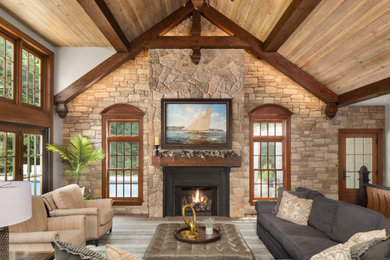 Huge elegant open concept exposed beam living room photo in Minneapolis with a stacked stone fireplace