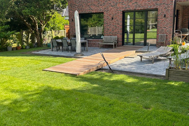 Mittelgroßer Country Garten im Sommer mit Auffahrt und Betonboden in Hamburg