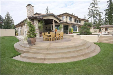 Example of a large classic backyard patio design in Seattle with a roof extension