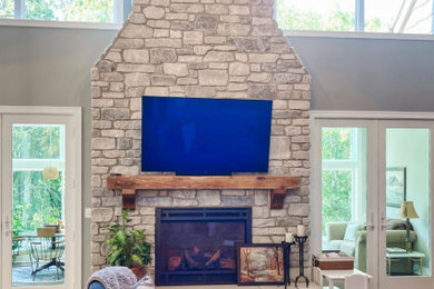 Huge country vinyl floor, brown floor and vaulted ceiling living room photo in Chicago with green walls, a standard fireplace and a stone fireplace