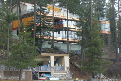 Huge contemporary three-story glass flat roof idea in Seattle