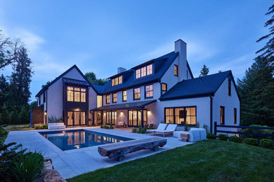 Aménagement d'une grande façade de maison blanche classique à deux étages et plus avec un revêtement mixte, un toit à deux pans, un toit mixte et un toit noir.