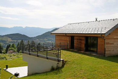 Idées déco pour une façade de maison montagne en bois à un étage avec un toit à deux pans.