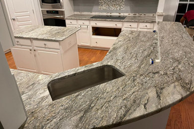 Example of a minimalist kitchen design in Raleigh with granite countertops, gray backsplash, subway tile backsplash and multicolored countertops