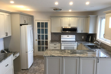 Enclosed kitchen - mid-sized transitional u-shaped vinyl floor and gray floor enclosed kitchen idea in Other with an undermount sink, shaker cabinets, gray cabinets, granite countertops, gray backsplash, subway tile backsplash, white appliances, a peninsula and gray countertops