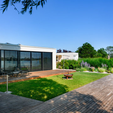 Moderner Seegarten mit großzügiger Holzterrasse