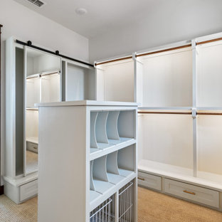 Immagine di una grande cabina armadio unisex country con ante con bugna sagomata, ante bianche, moquette, pavimento beige e soffitto a volta
