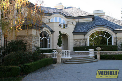 Large traditional beige two-story stone house exterior idea in San Francisco with a shingle roof