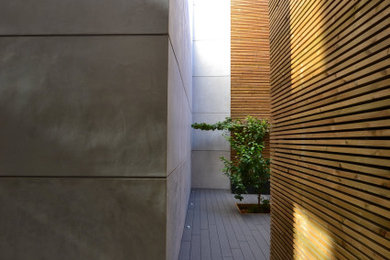 Imagen de patio moderno de tamaño medio en patio trasero con suelo de baldosas