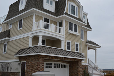 Example of a beach style beige three-story mixed siding exterior home design in Philadelphia