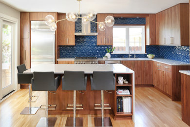 シカゴにある高級な中くらいなミッドセンチュリースタイルのおしゃれなキッチン (シングルシンク、フラットパネル扉のキャビネット、中間色木目調キャビネット、珪岩カウンター、青いキッチンパネル、セラミックタイルのキッチンパネル、シルバーの調理設備、淡色無垢フローリング、ベージュの床、白いキッチンカウンター) の写真