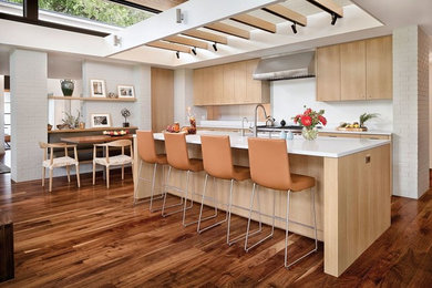 Example of a transitional galley dark wood floor open concept kitchen design in Austin with flat-panel cabinets, light wood cabinets, quartzite countertops, white backsplash, stainless steel appliances, an island and a single-bowl sink
