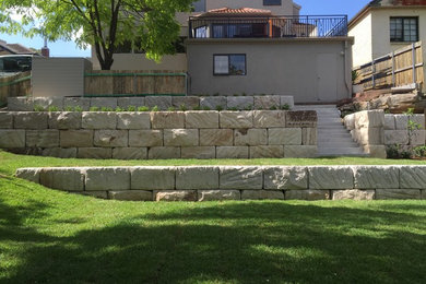 Inspiration for a contemporary front yard garden in Other with a retaining wall.