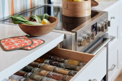 Example of a mid-century modern light wood floor and beige floor kitchen design in San Francisco with quartz countertops, multicolored backsplash, ceramic backsplash, white countertops, shaker cabinets, white cabinets, an island and an undermount sink