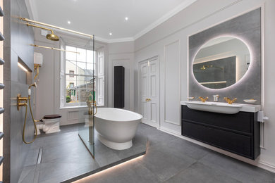 Inspiration for a large traditional kids bathroom in Edinburgh with flat-panel cabinets, black cabinets, a freestanding tub, an open shower, a two-piece toilet, gray tile, porcelain tile, white walls, porcelain floors, grey floor, an open shower, a niche, a double vanity, a floating vanity and panelled walls.