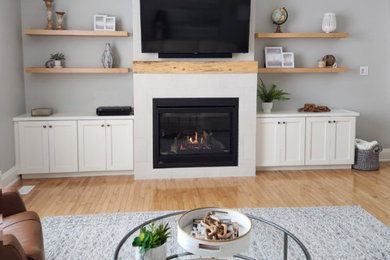 Family room - large contemporary open concept light wood floor and beige floor family room idea in Toronto with blue walls, a two-sided fireplace, a tile fireplace and a wall-mounted tv