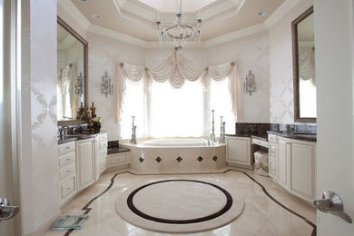 Photo of a large traditional master bathroom in New York with white cabinets, a drop-in tub, white walls and an undermount sink.