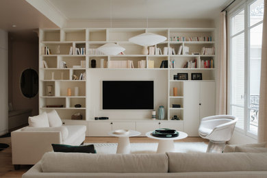 Living room - scandinavian medium tone wood floor and brown floor living room idea in Paris with white walls and a media wall