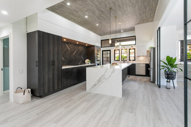 Example of a large minimalist u-shaped vinyl floor, gray floor and wood ceiling eat-in kitchen design in Hawaii with a farmhouse sink, flat-panel cabinets, quartz countertops, ceramic backsplash, stainless steel appliances, an island and white countertops