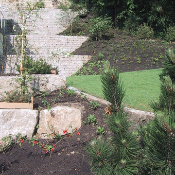 Hausgarten in Hanglage mit Natursteinmauern