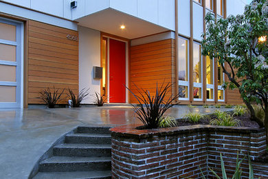 Inspiration for a contemporary entryway remodel in Seattle with a red front door