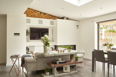 Minimalist open concept porcelain tile and gray floor living room photo in Essex with white walls, a corner fireplace, a plaster fireplace and a wall-mounted tv
