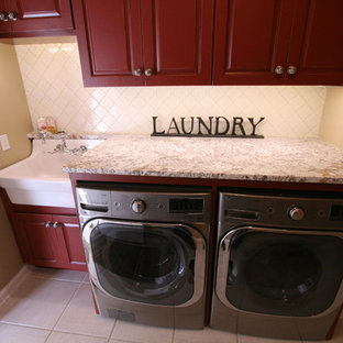 Ejemplo de lavadero en L, de estilo de casa de campo, con armarios con paneles con relieve, puertas de armario de madera en tonos medios y lavadora y secadora juntas