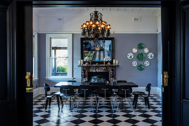 This is an example of an expansive traditional dining room in Singapore with blue walls, ceramic floors and black floor.
