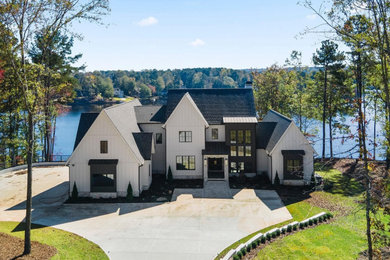 Inspiration for a large transitional white two-story concrete fiberboard and board and batten exterior home remodel in Atlanta with a shingle roof and a black roof