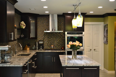 Photo of a mid-sized modern l-shaped open plan kitchen in Atlanta with an undermount sink, flat-panel cabinets, dark wood cabinets, granite benchtops, multi-coloured splashback, mosaic tile splashback, stainless steel appliances, porcelain floors, with island and beige floor.