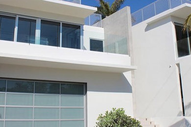 Large trendy white three-story exterior home photo in Miami