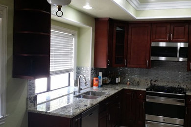 Kitchen - mid-sized contemporary u-shaped ceramic tile and beige floor kitchen idea in Orange County with an undermount sink, raised-panel cabinets, dark wood cabinets, granite countertops, metallic backsplash, matchstick tile backsplash, stainless steel appliances and no island
