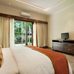 Immagine di una grande camera matrimoniale etnica con pareti beige e pavimento in marmo