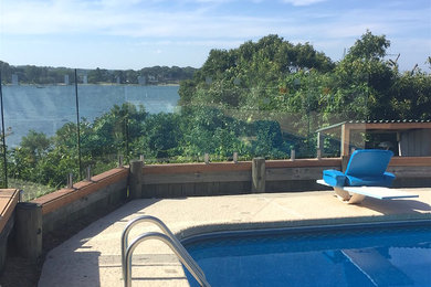 Ejemplo de casa de la piscina y piscina minimalista de tamaño medio en patio trasero con losas de hormigón