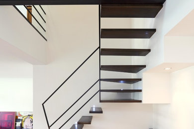 Mid-sized contemporary metal l-shaped staircase in Paris with open risers.