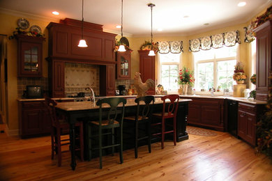 Mid-sized elegant u-shaped medium tone wood floor and brown floor enclosed kitchen photo in Chicago with raised-panel cabinets, dark wood cabinets, granite countertops, beige backsplash, ceramic backsplash, black appliances and an island