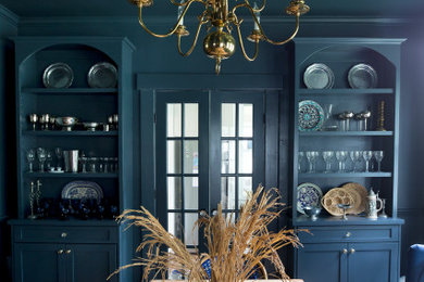 Imagen de comedor tradicional con paredes azules, suelo de madera en tonos medios y suelo marrón
