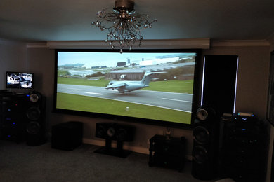 Inspiration for a medium sized contemporary open plan home cinema in Berkshire with a projector screen.