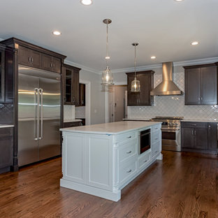 Traditional kitchen pantry designs - Inspiration for a timeless dark wood floor and brown floor kitchen pantry remodel in Newark with a farmhouse sink, shaker cabinets, dark wood cabinets, white backsplash, ceramic backsplash, stainless steel appliances and an island